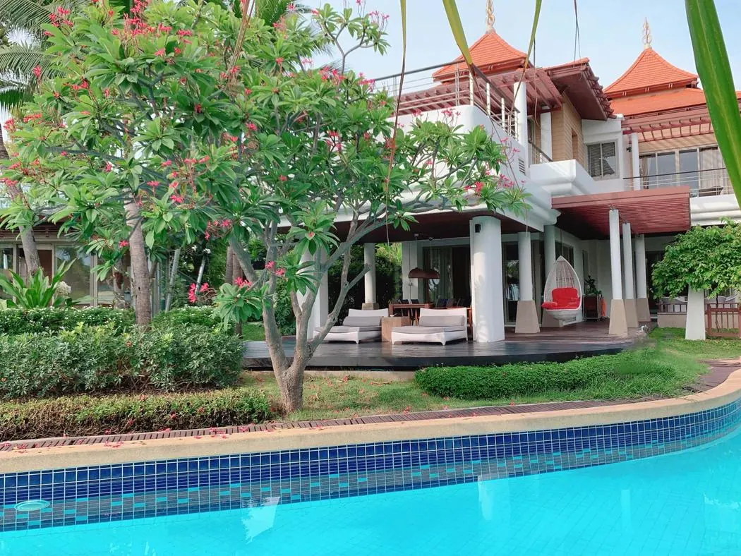 The Main Villa seen across the pool, frangipani in flower beside the covered terrace