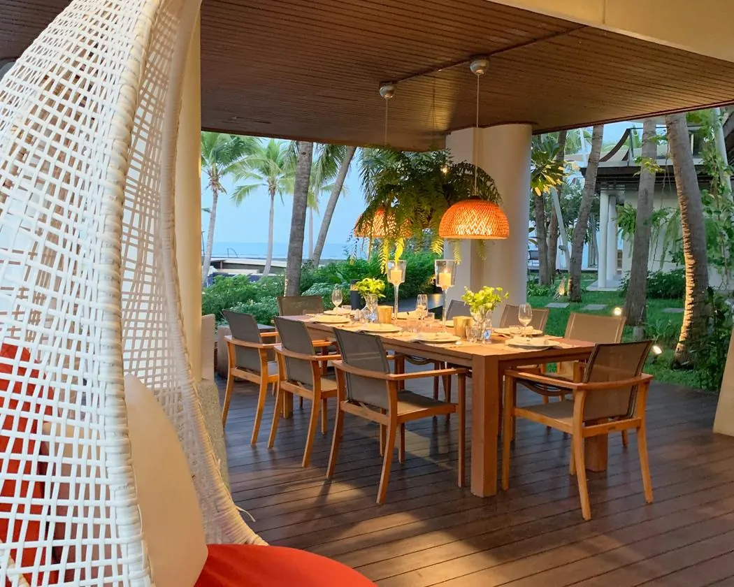 Ground floor: the covered terrace dining table set for dinner, sea beyond