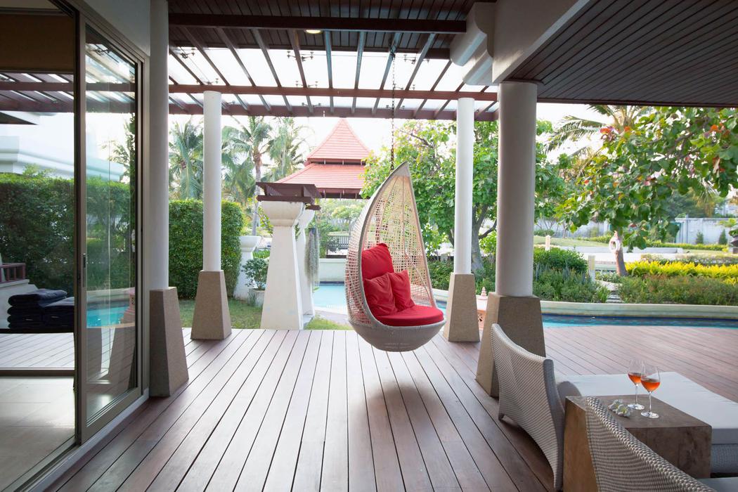 Ground floor: covered outdoor lounge with hanging chair beside the pool