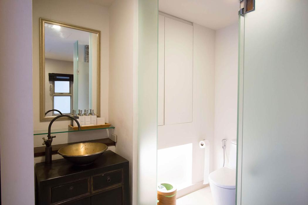 The 2nd Pavilion vanity with a brass basin beside the glass shower