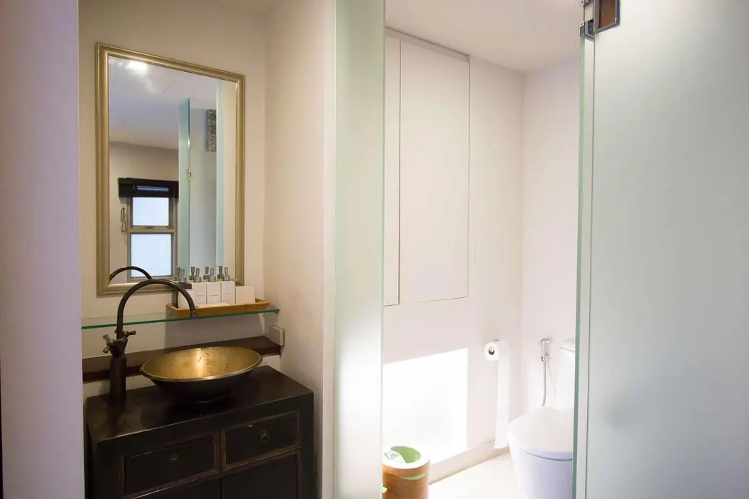 The 2nd Pavilion vanity with a brass basin beside the glass shower