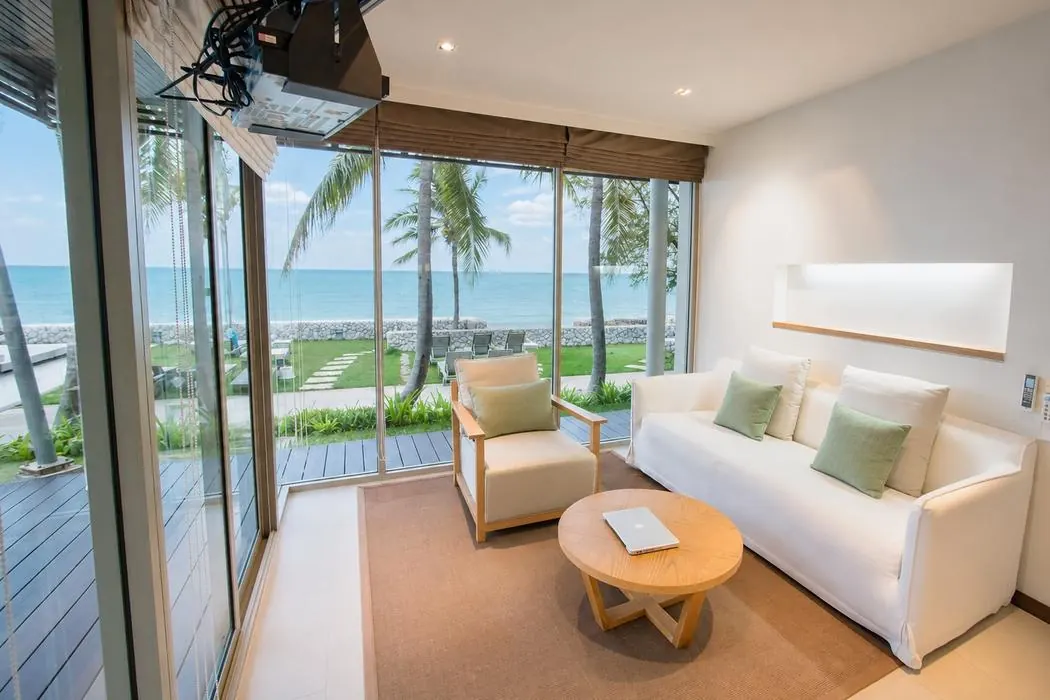Sofa and coffee table in the Beachfront Pavilion living room, glass wall to the terrace