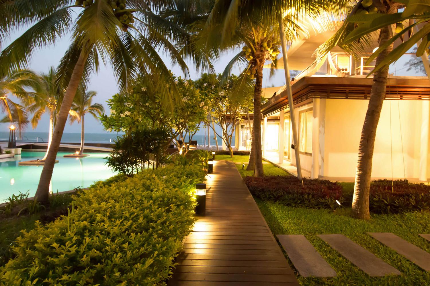 Lit timber walkway between the pavilions at dawn