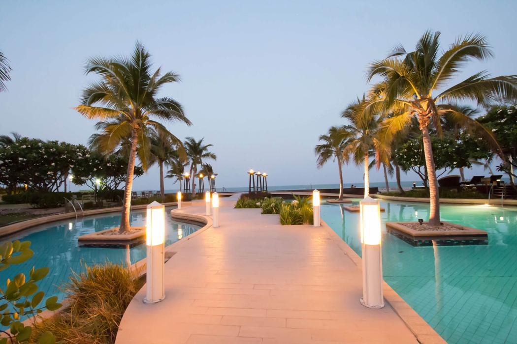 The estate pools and the lit walkway at dusk