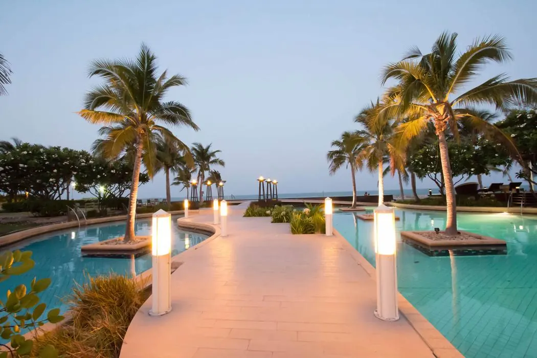The estate pools and the lit walkway at dusk