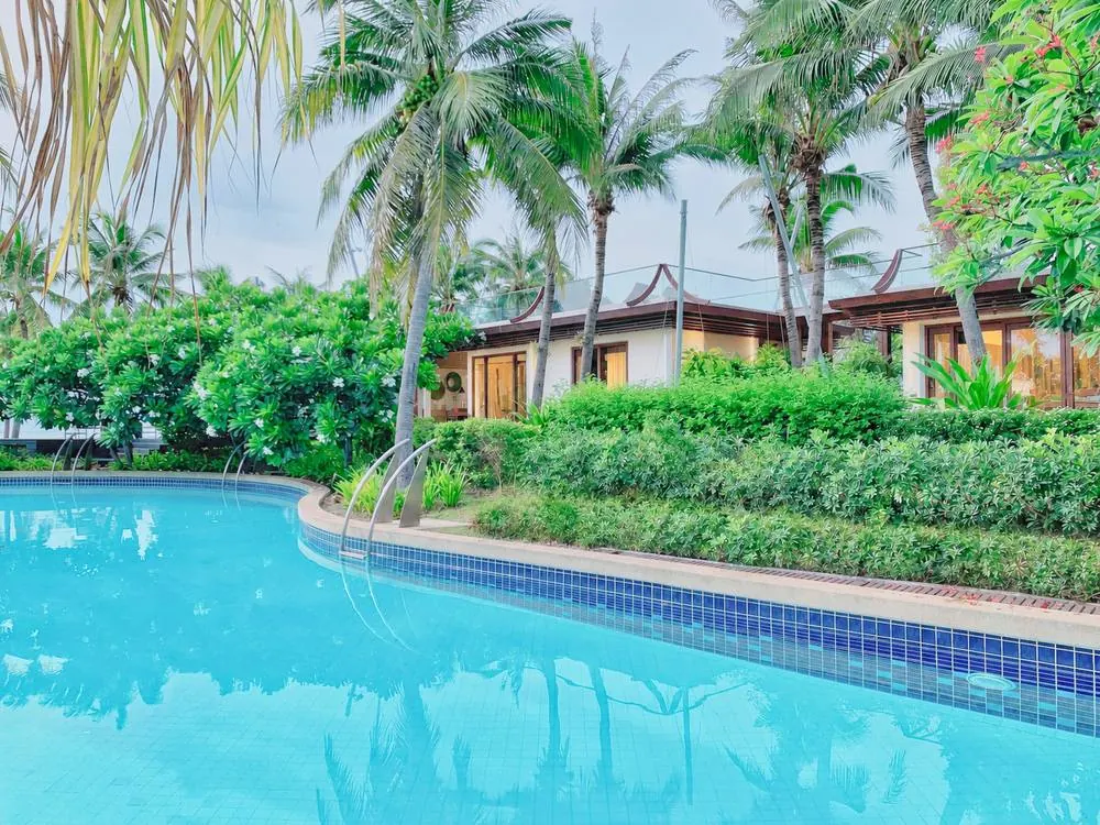 The villa and pavilions seen across the pool
